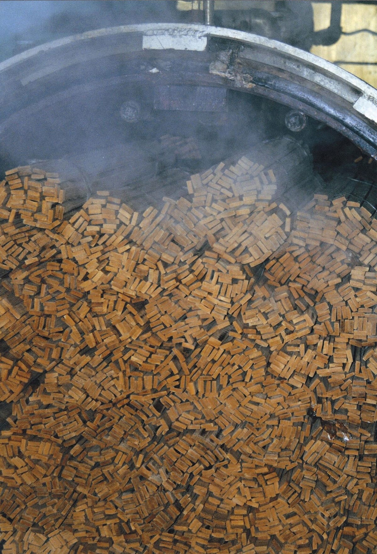 MOSO-Bambus-Produktion: Bambus­streifen werden in der industriellen Verarbeitung unter Dampf flach­gepresst — Vorstufe zu Lamellen, geflachten Halmen und Strand-Woven-Density
